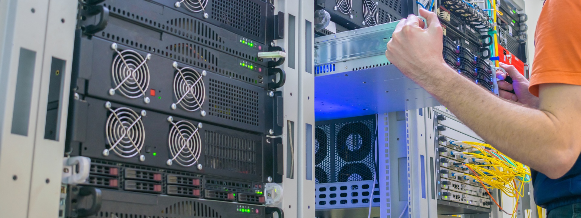 A Technician Repairs The Central Router. A Man Works In A Server Room. System Administrator Installs A New Server In A Modern Data Center.